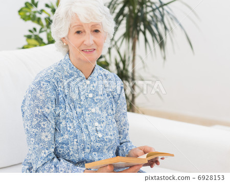 Elderly cheerful woman reading a old novel 6928153