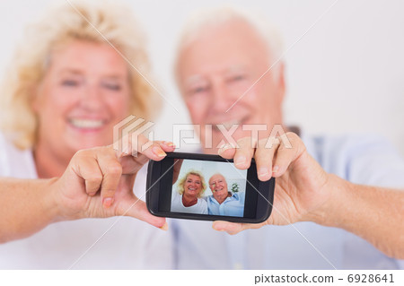 Old couple taking pictures with a smartphone Old couple taking pictures with a smartphone 6928641