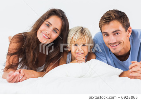 Family lying on a bed together 6928865