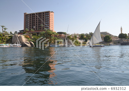 Fawluka floating on the Nile River flowing through Aswan, a luxury hotel stands Fawluka floating on the Nile River flowing through Aswan, a luxury hotel stands 6932312