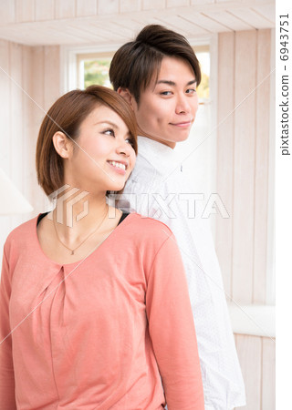 Young couple standing back to back 6943751