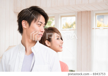 Young couple standing back to back Young couple standing back to back 6943753