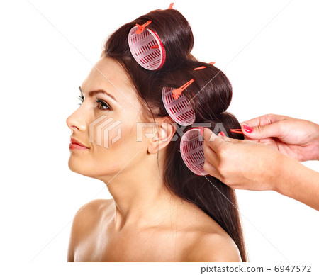 Woman wear hair curlers on head. 6947572