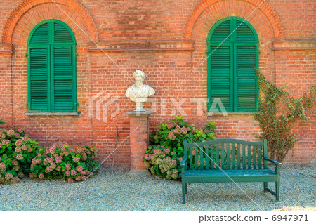 Wooden bench in front of red brick house in Italy. 6947971