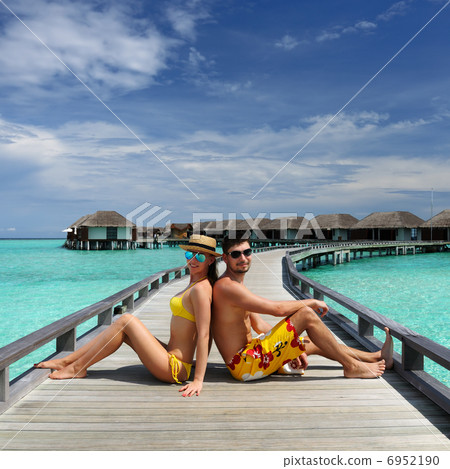 Couple on a beach jetty at Maldives Couple on a beach jetty at Maldives 6952190