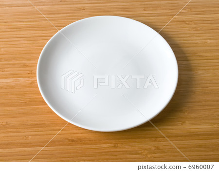 white plate on a bamboo table top 6960007