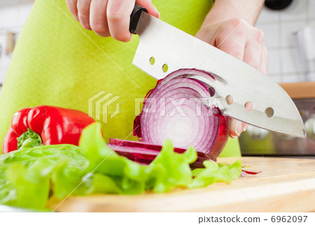 Woman's hands cutting bulb onion Woman's hands cutting bulb onion 6962097