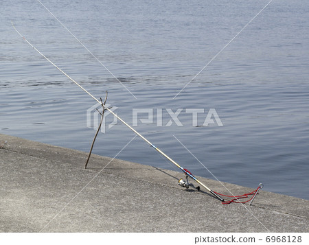 Fishing rod set in riverbed 6968128