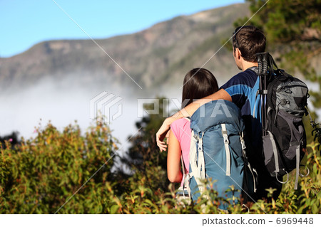 Couple hiking looking at view Couple hiking looking at view 6969448