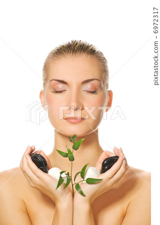 Beautiful blond girl holding young plant growing up through ston Beautiful blond girl holding young plant growing up through ston 6972317