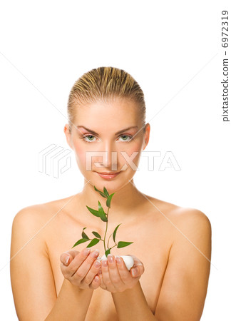 Beautiful blond girl holding young plant growing up through ston Beautiful blond girl holding young plant growing up through ston 6972319