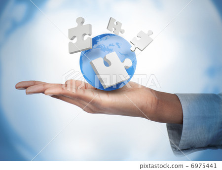 Hand with digital puzzles and a globe 6975441