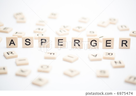 Asperger spelled out in plastic letter pieces with others scatte 6975474