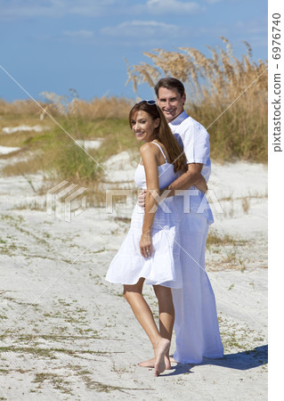 Romantic Man and Woman Couple Walking on An Empty Beach Romantic Man and Woman Couple Walking on An Empty Beach 6976740