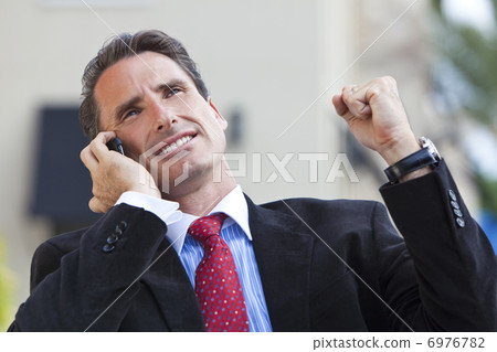 Male Executive Businessman Celebrating Success On Cell Phone Male Executive Businessman Celebrating Success On Cell Phone 6976782