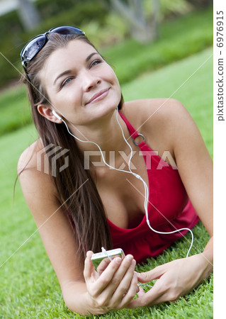 Beautiful Brunette Woman laying Down Listening to MP3 Player Beautiful Brunette Woman laying Down Listening to MP3 Player 6976915