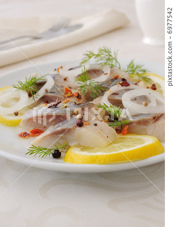 Slices of salted herring with onion, lemon and spices Slices of salted herring with onion, lemon and spices 6977542
