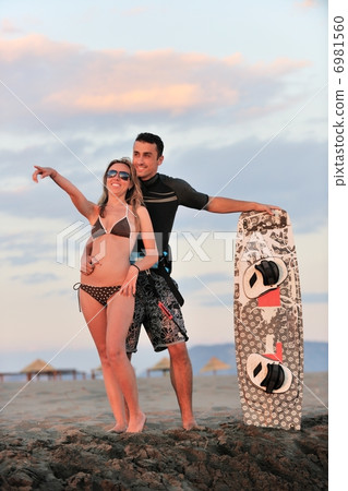 surf couple posing at beach on sunset surf couple posing at beach on sunset 6981560