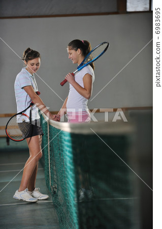 young girls playing tennis game indoor 6983695