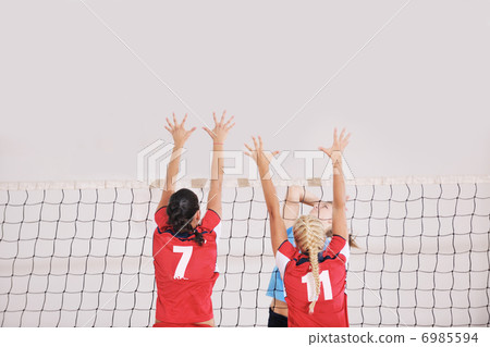 girls playing volleyball indoor game 6985594