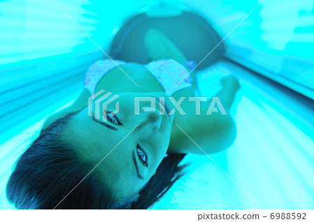 Beautiful young woman tanning in solarium Beautiful young woman tanning in solarium 6988592