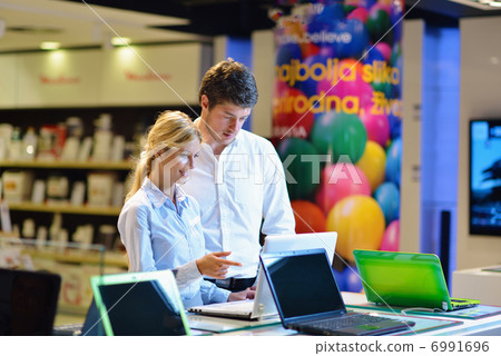 Young couple in consumer electronics store Young couple in consumer electronics store 6991696