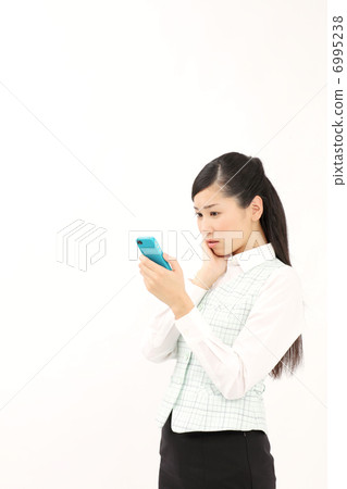 一個女人看著智能手機(擔心) 一個女人看著智能手機(擔心) 6995238