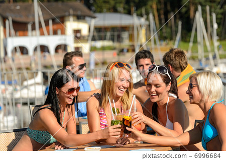 Beautiful women in bikinis toasting with cocktails 6996684