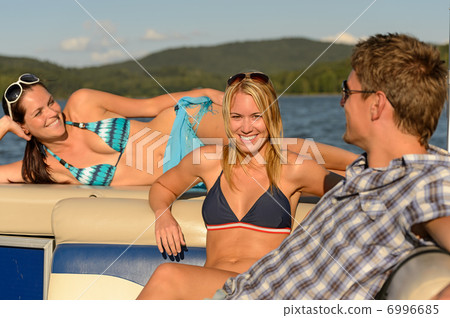 Sunbathing friends lying on summer yacht Sunbathing friends lying on summer yacht 6996685
