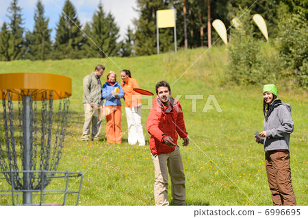 Couple throwing frisbee disc at springtime park Couple throwing frisbee disc at springtime park 6996695