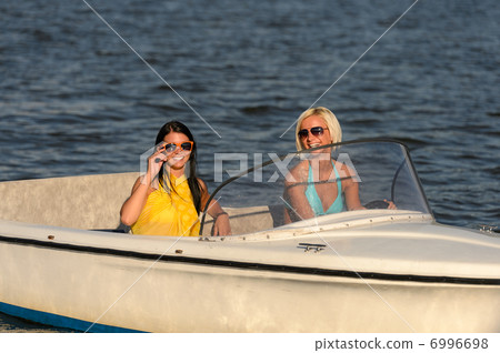 Young women in sunglasses sitting in motorboat 6996698