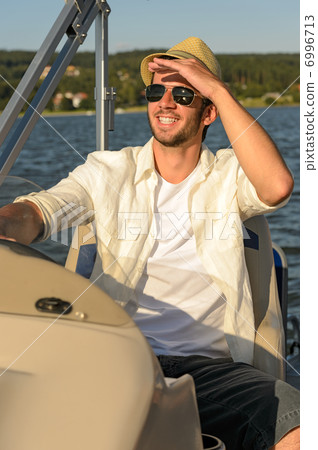 Young man navigating powerboat sunny 6996713