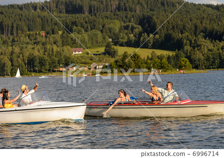 Young friends having fun in motorboats Young friends having fun in motorboats 6996714