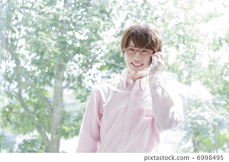 A smiling man who puts his smartphone on his ear A smiling man who puts his smartphone on his ear 6998495