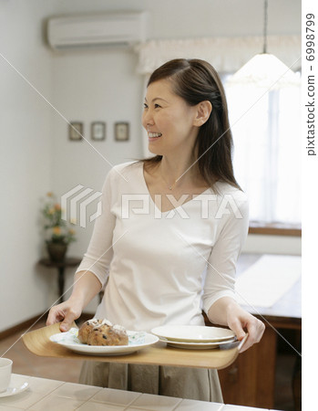 A woman carrying a cake A woman carrying a cake 6998799