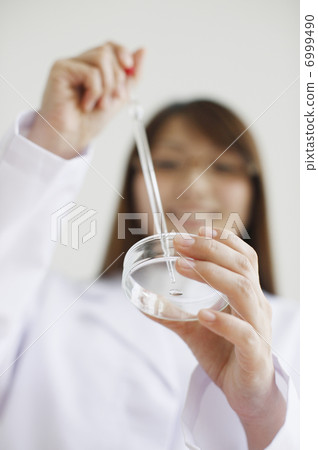 A woman with a petri dish 6999490