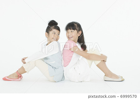 Girls sitting back to back Girls sitting back to back 6999570