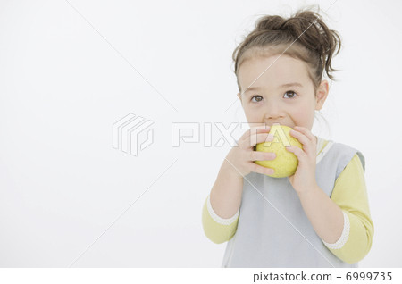 A girl who eats a green apple 6999735