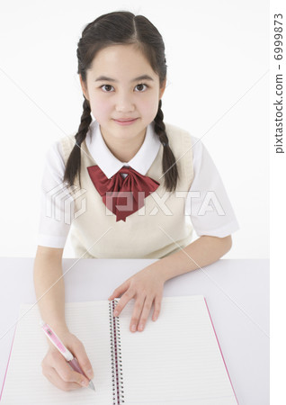 Girls junior high school students writing in notes 6999873