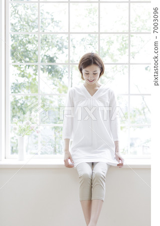 A woman sitting on the window side 7003096