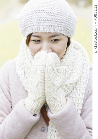 A woman wearing a glove and covering her mouth A woman wearing a glove and covering her mouth 7003112
