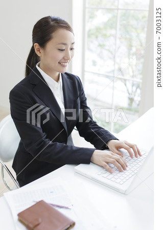 朝向便攜式計算機的女商人 朝向便攜式計算機的女商人 7003125
