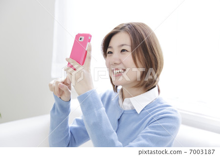 A woman watching a mobile phone 7003187