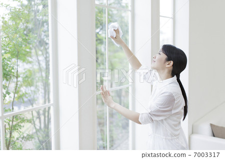 A woman wiping a window A woman wiping a window 7003317