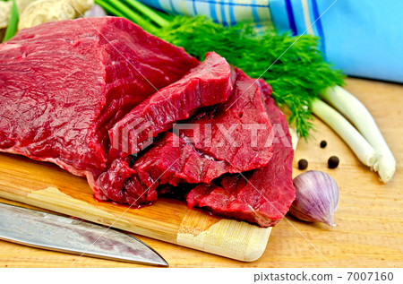Meat beef on a wooden board with a knife Meat beef on a wooden board with a knife 7007160