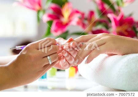 Woman in nail salon receiving manicure 7007572