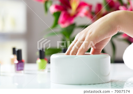 Woman in nail salon receiving manicure Woman in nail salon receiving manicure 7007574