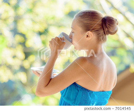 Young woman drinking coffee on morning terrace Young woman drinking coffee on morning terrace 7014545