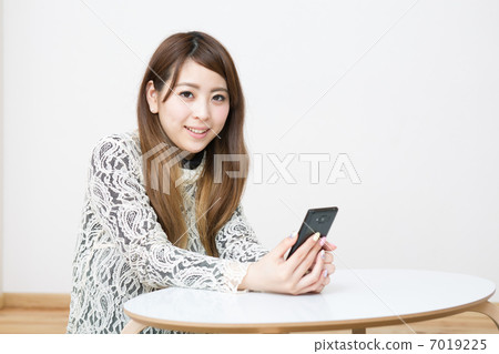 A woman watching a smartphone A woman watching a smartphone 7019225