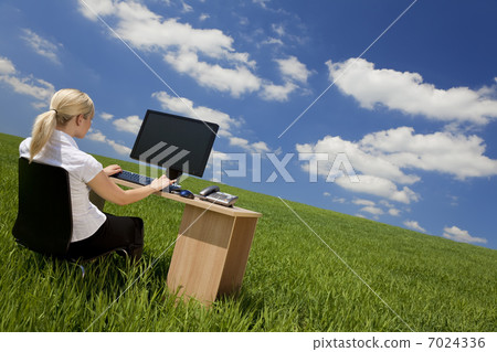 Businesswoman Using Computer In A Green Field 7024336